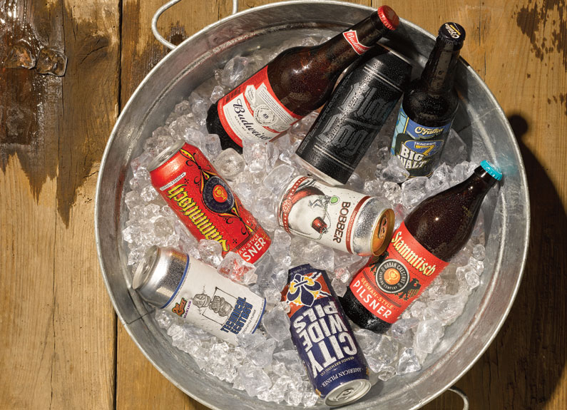 several bottled and canned lagers in a bucket of ice