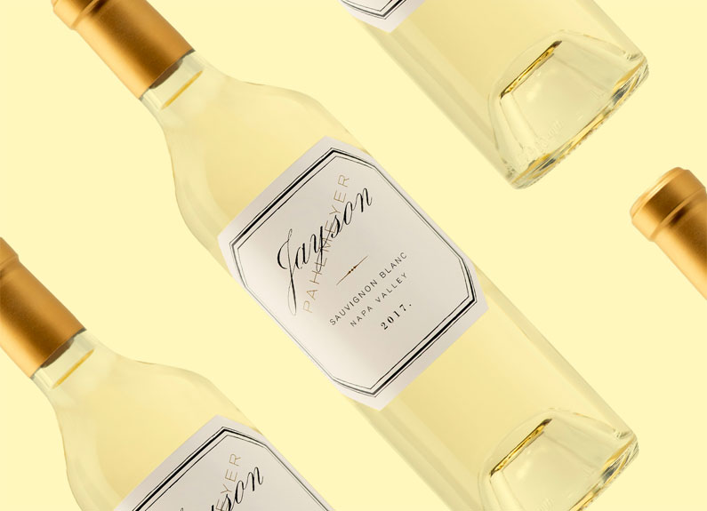 several bottles of white wine against a pale yellow backdrop