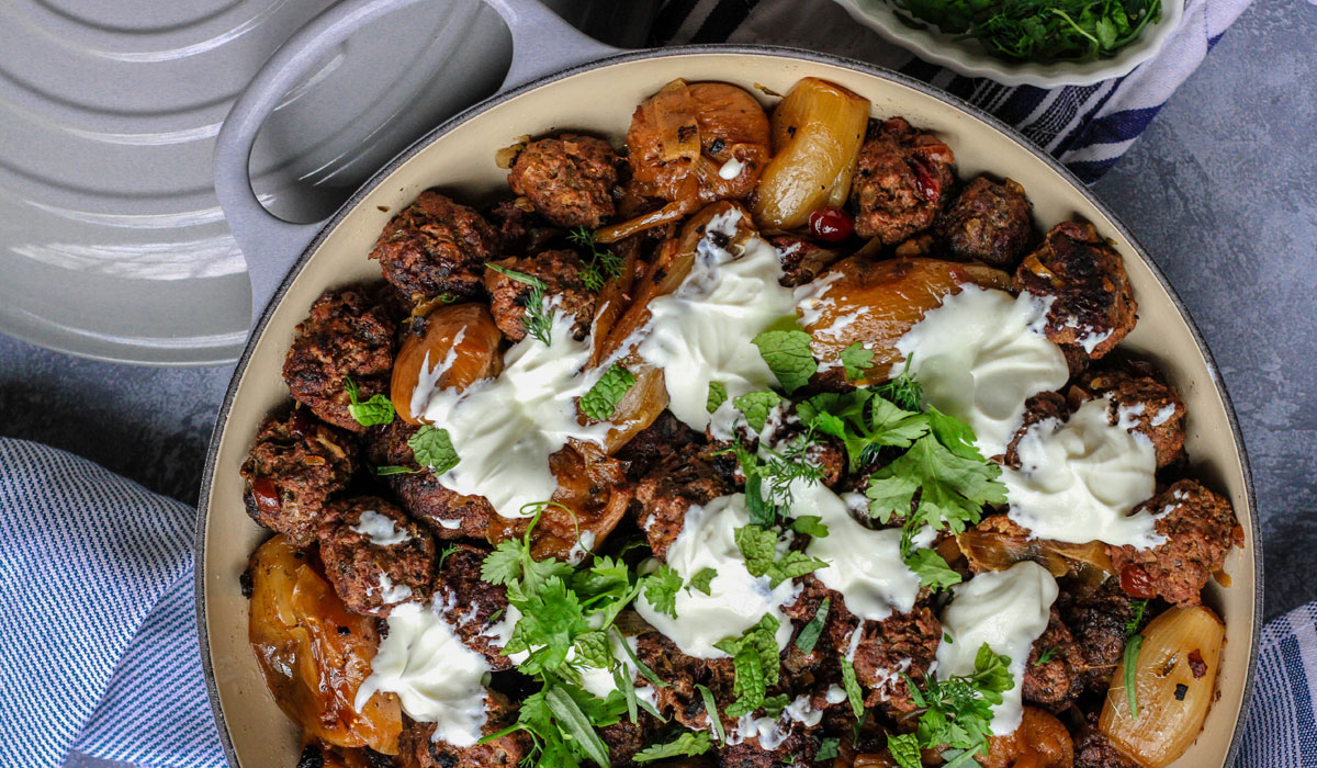 a pan of moroccan meatballs with herbed yogurt