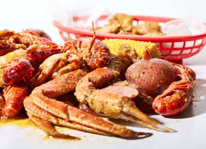 a pile of red crawfish, corn and sausages