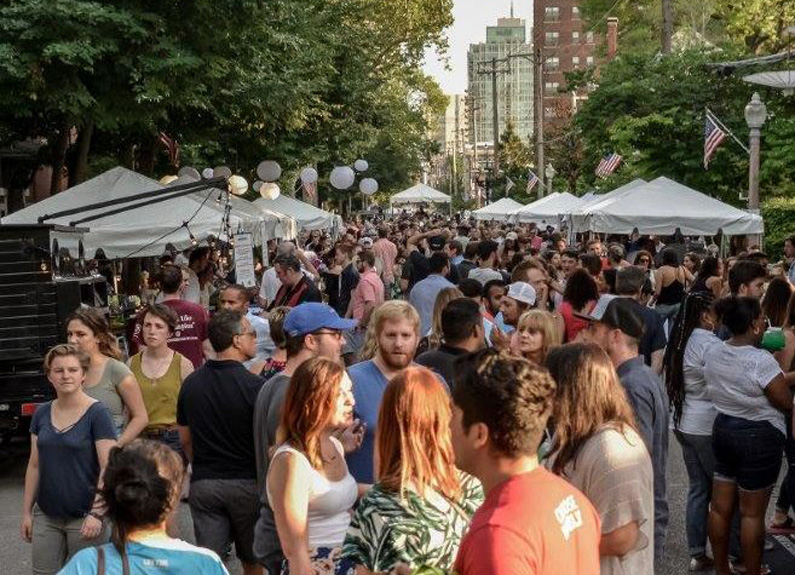 a crowd of people at an outdoor street festival