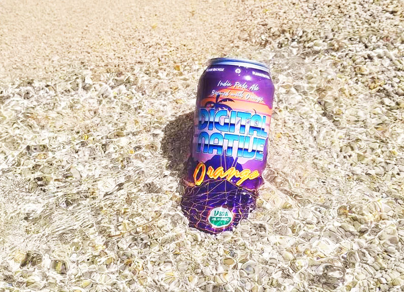 a can of beer on a rocky river edge