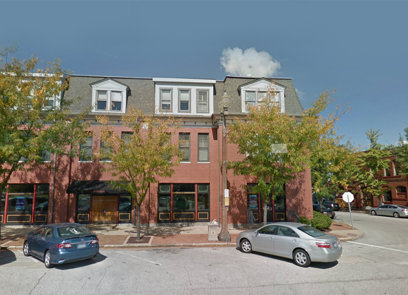 the exterior of a renovated firehouse on a tree-lined street