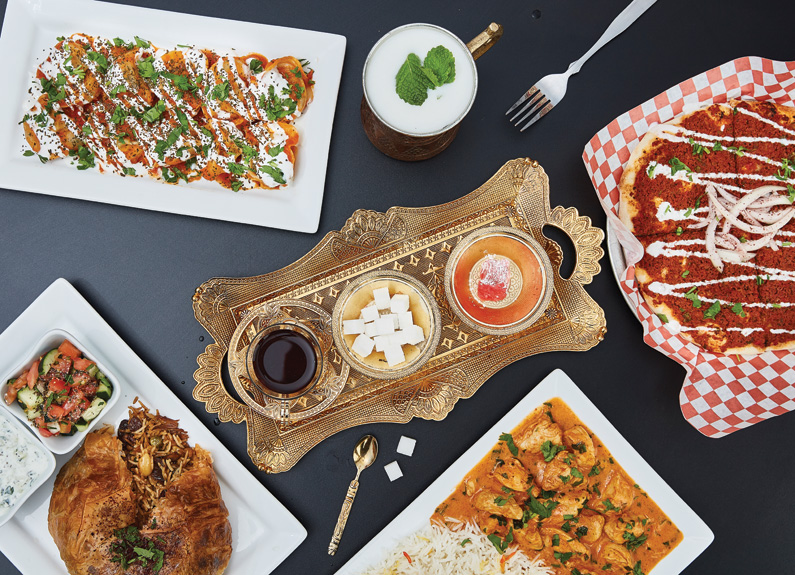 several middle eastern dishes and a tea service on a bronze tray