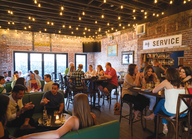 A brick-walled dining room with high-top tables