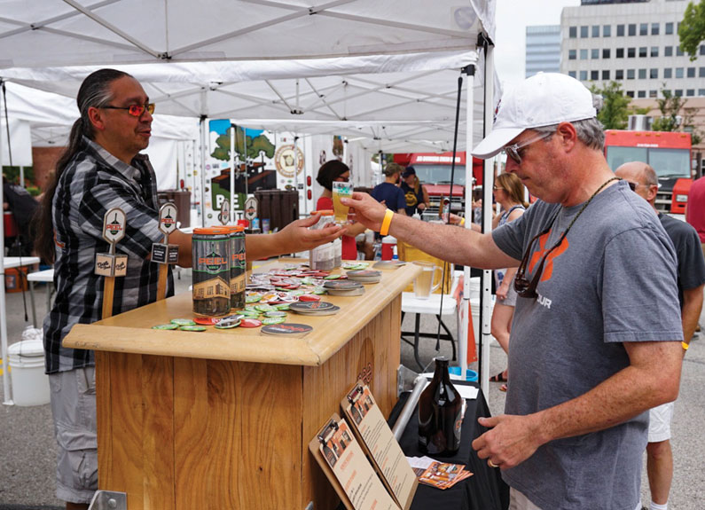 a man serving another man a small pour of beer