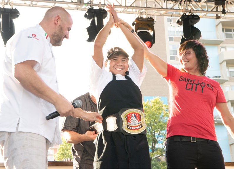 three people on a stage cheering