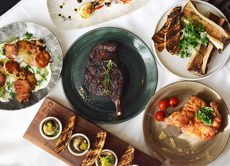 a steak surrounded by several dishes