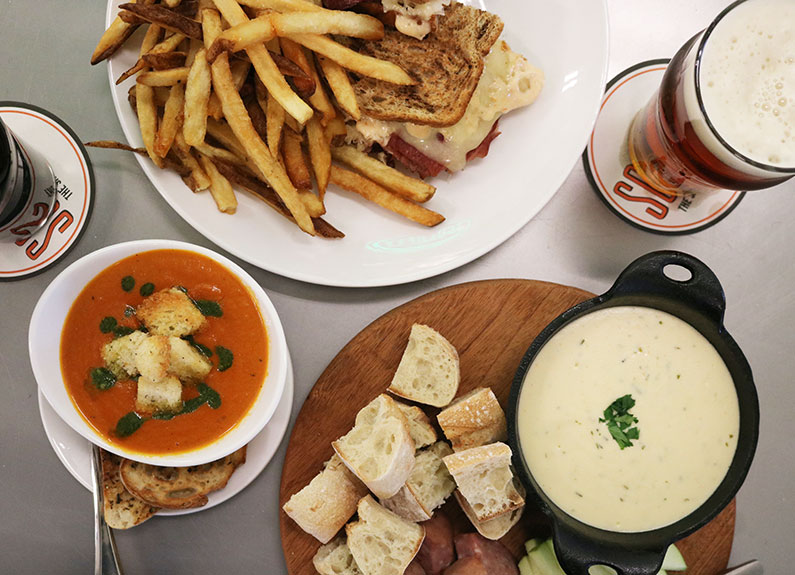 an assortment of dishes and beer from schlafly highland square’s menu