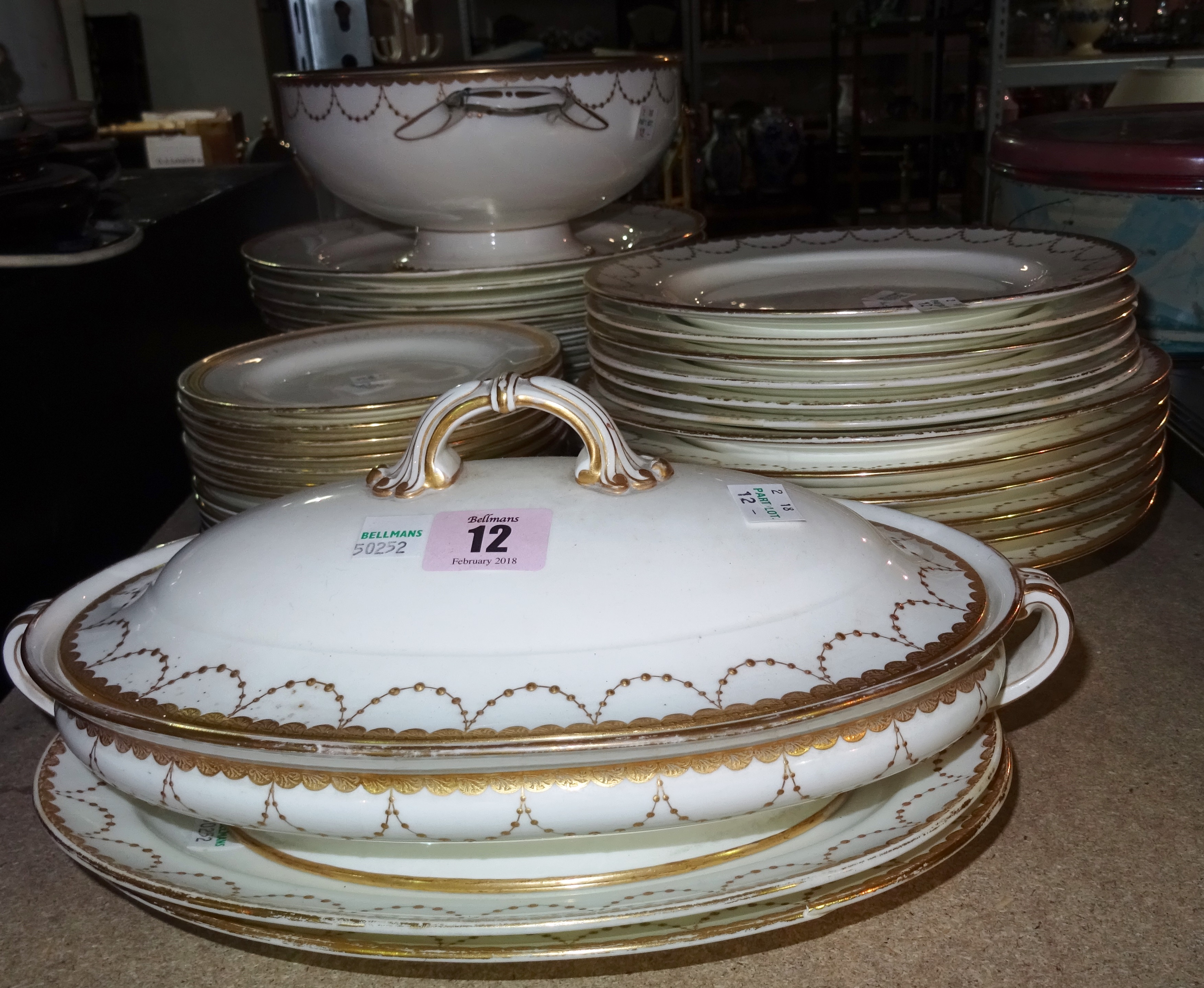 Mintons England; a part dinner service including a tureen and cover, another tureen lacking cover, two stands, twelve dinner plates, six soup bowls, s