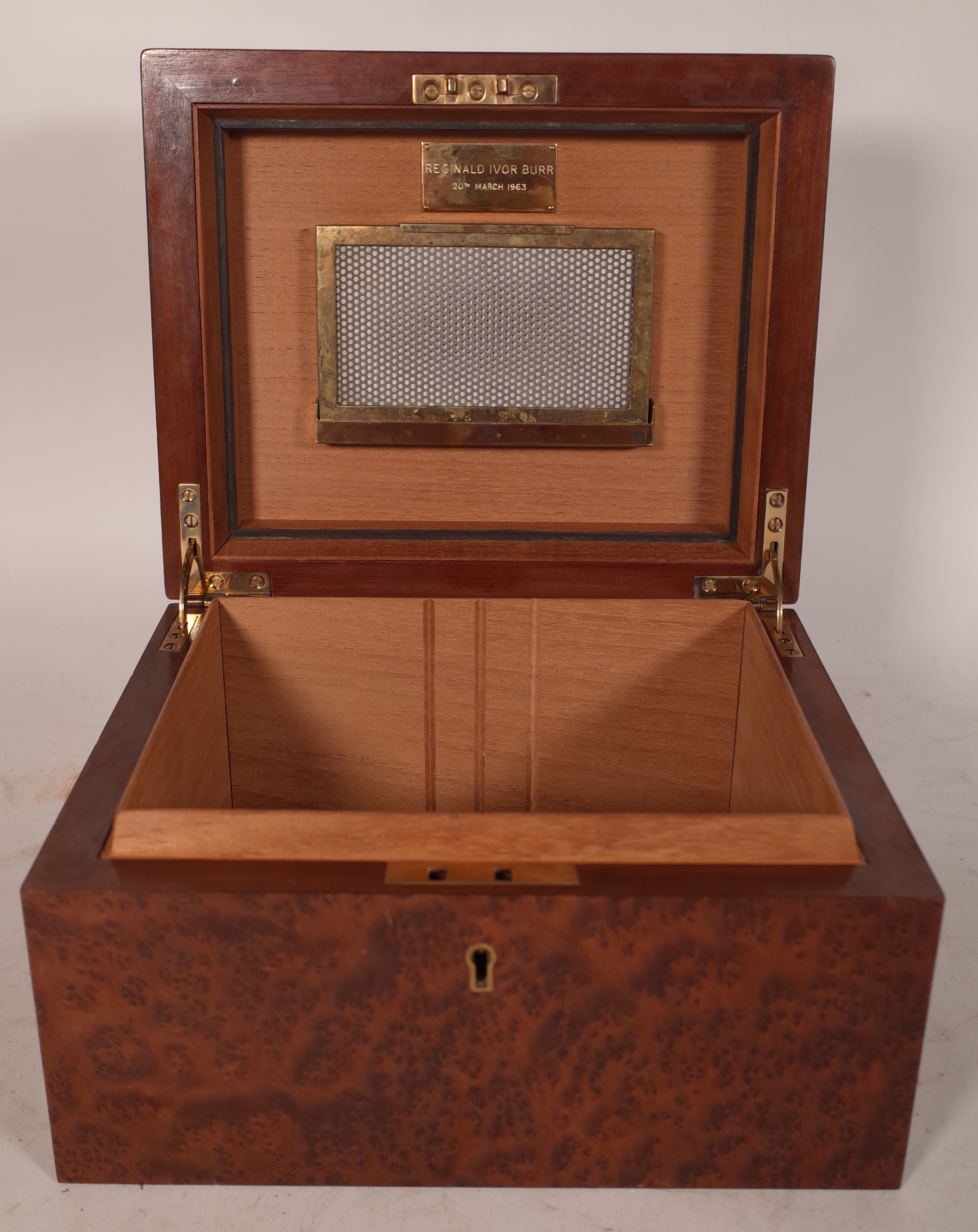 An Amboyna wood humidor, circa. 1960, with domed hinged lid over a rectangular body. 24.5cm wide. (key)