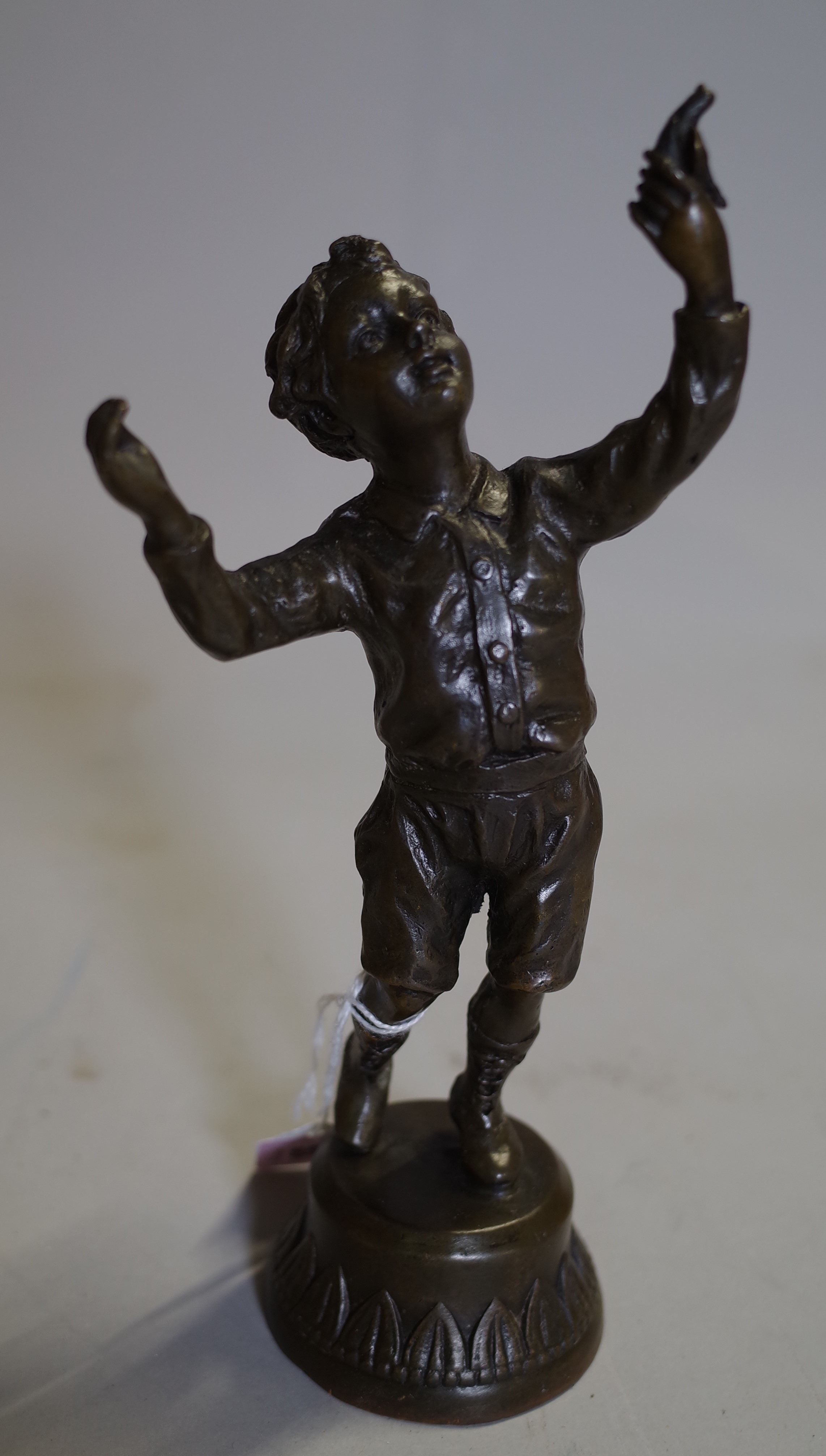 A 20th century bronze figure of a boy holding a bird, 22cm high.