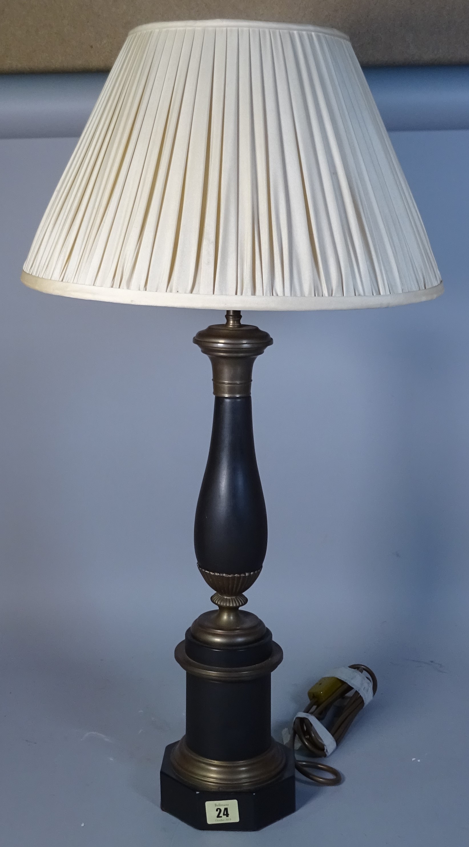 A 20th century gilt metal table lamp of baluster form, on a hexagonal foot, with a cream pleated shade, lamp 50cm high.