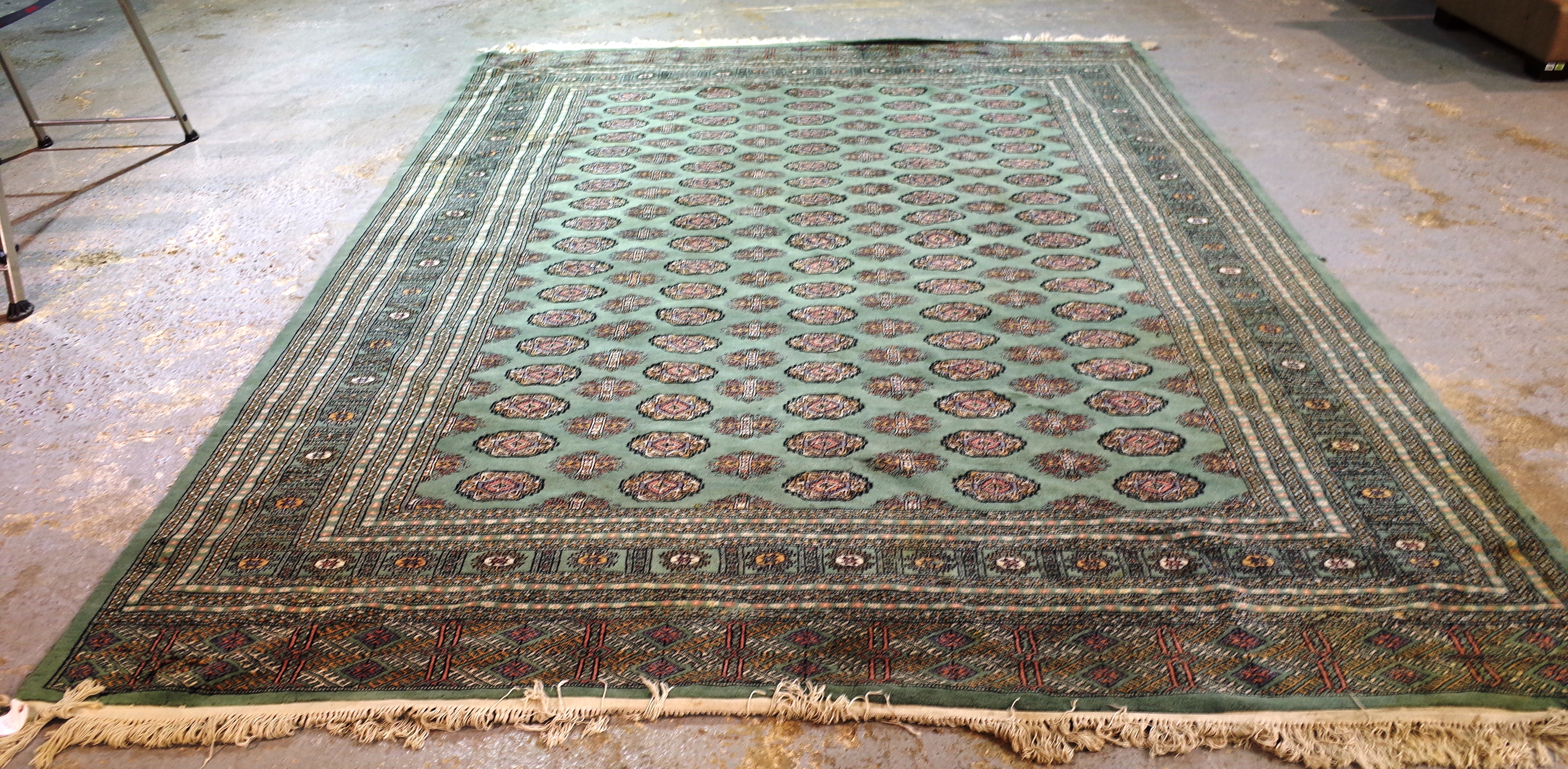 A green Pakistan Bokhara carpet, 380cm x 278cm.