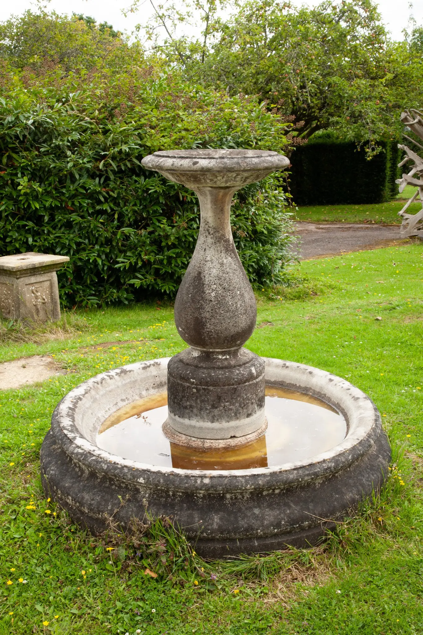 A carved white marble fountain and pool base
