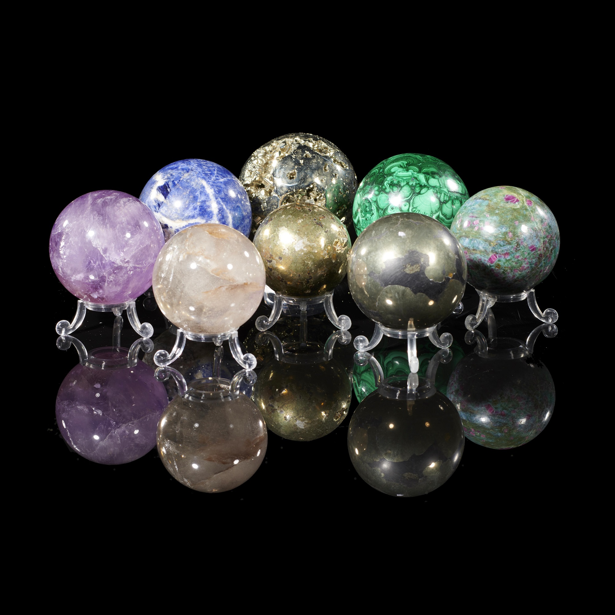 A collection of eight semi-precious stone spheres including malachite, pyrite, sodalite, amethyst, quartz, ruby in fuchsite the largest 7cm
