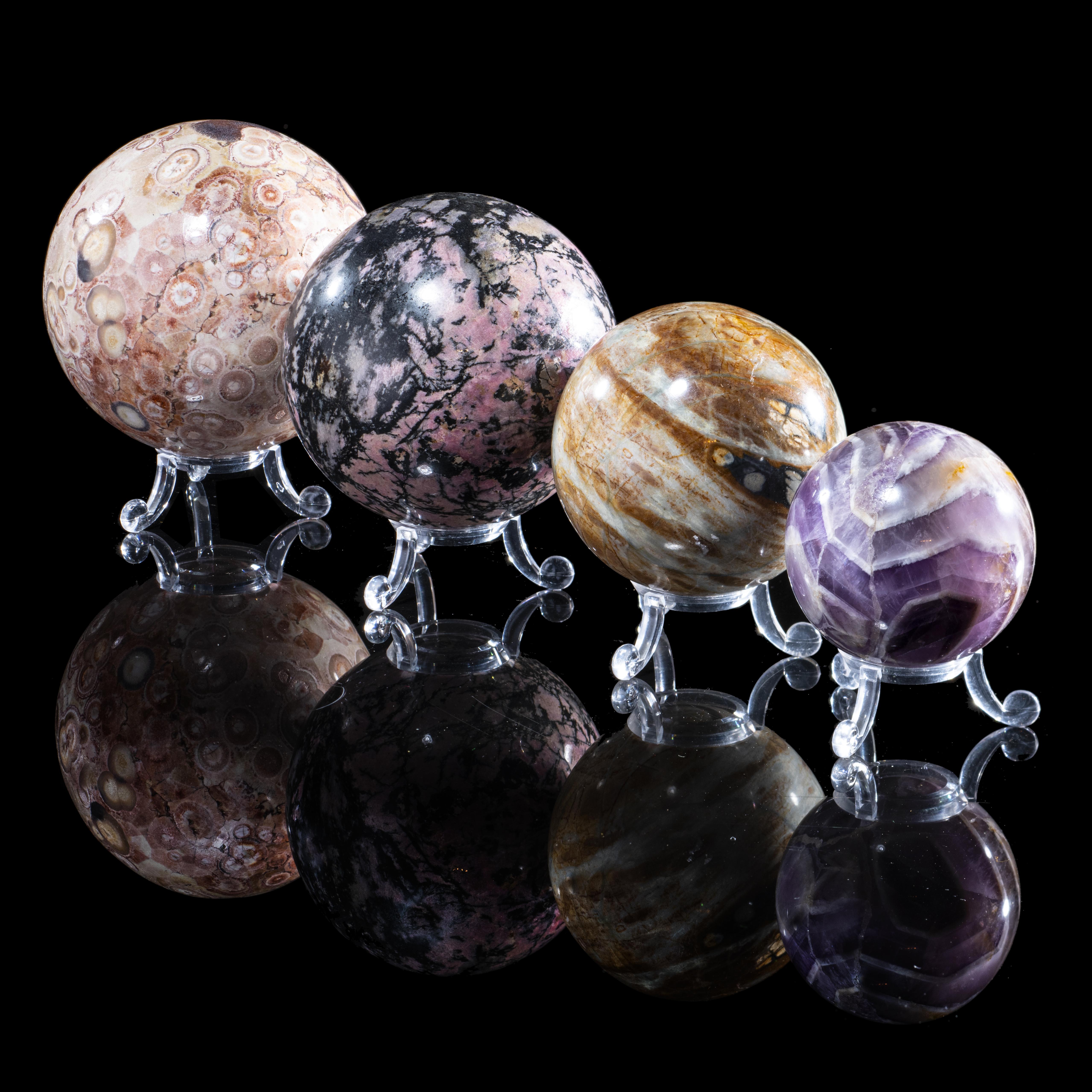 Four mineral spheres consisting of Fish eye jasper from Mexico, Rhodonite from Canada, Chevron amethyst from Brazil and Picasso stone from Utah,...