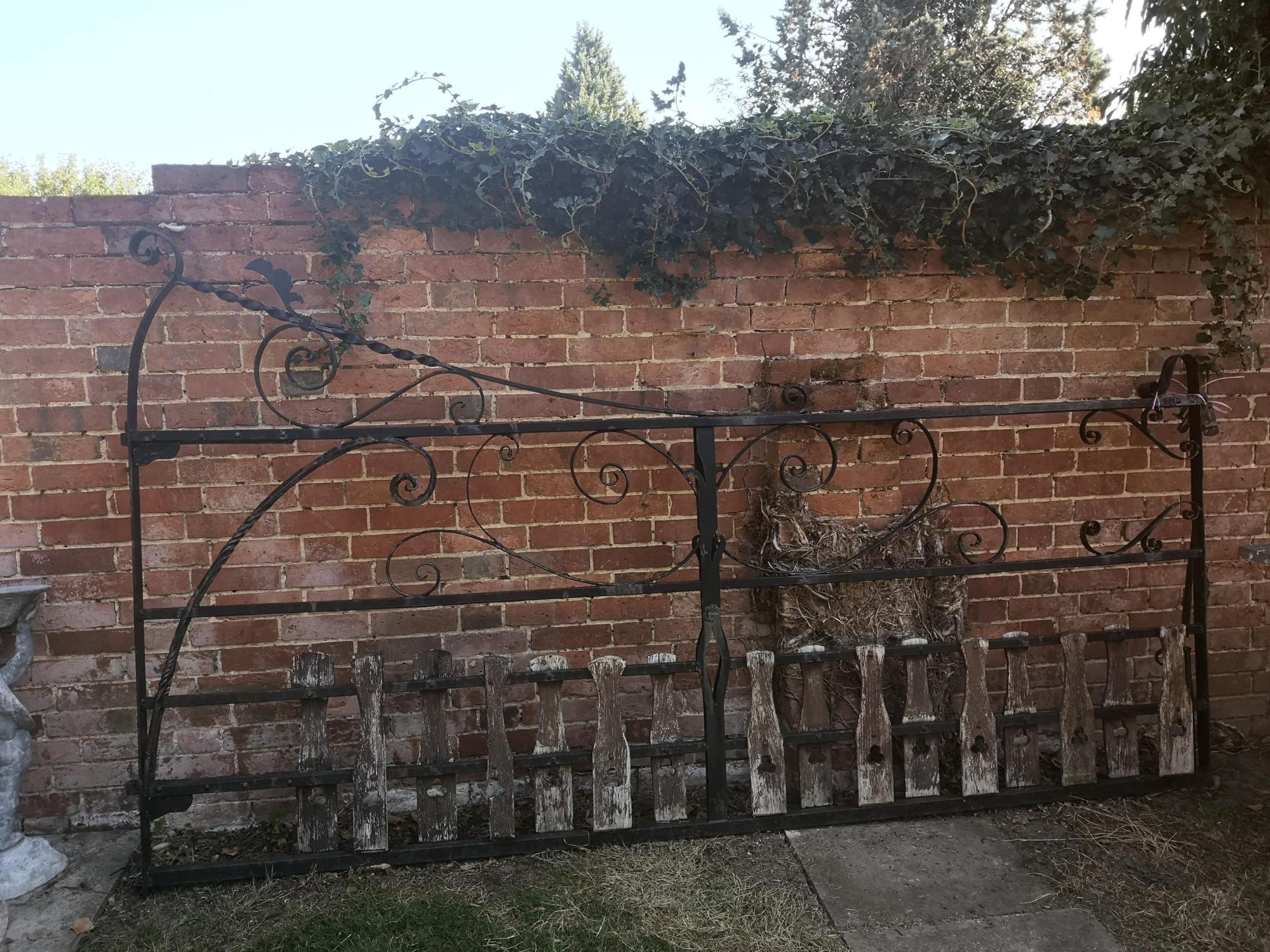 A wrought iron estate gate early 20th century with wooden dog guards 166cm high by 295cm long