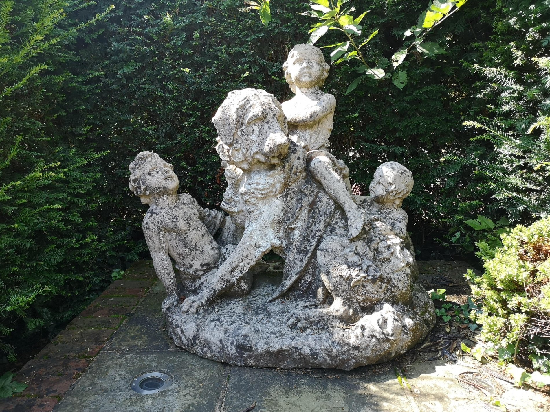 A composition stone group of a dog and children