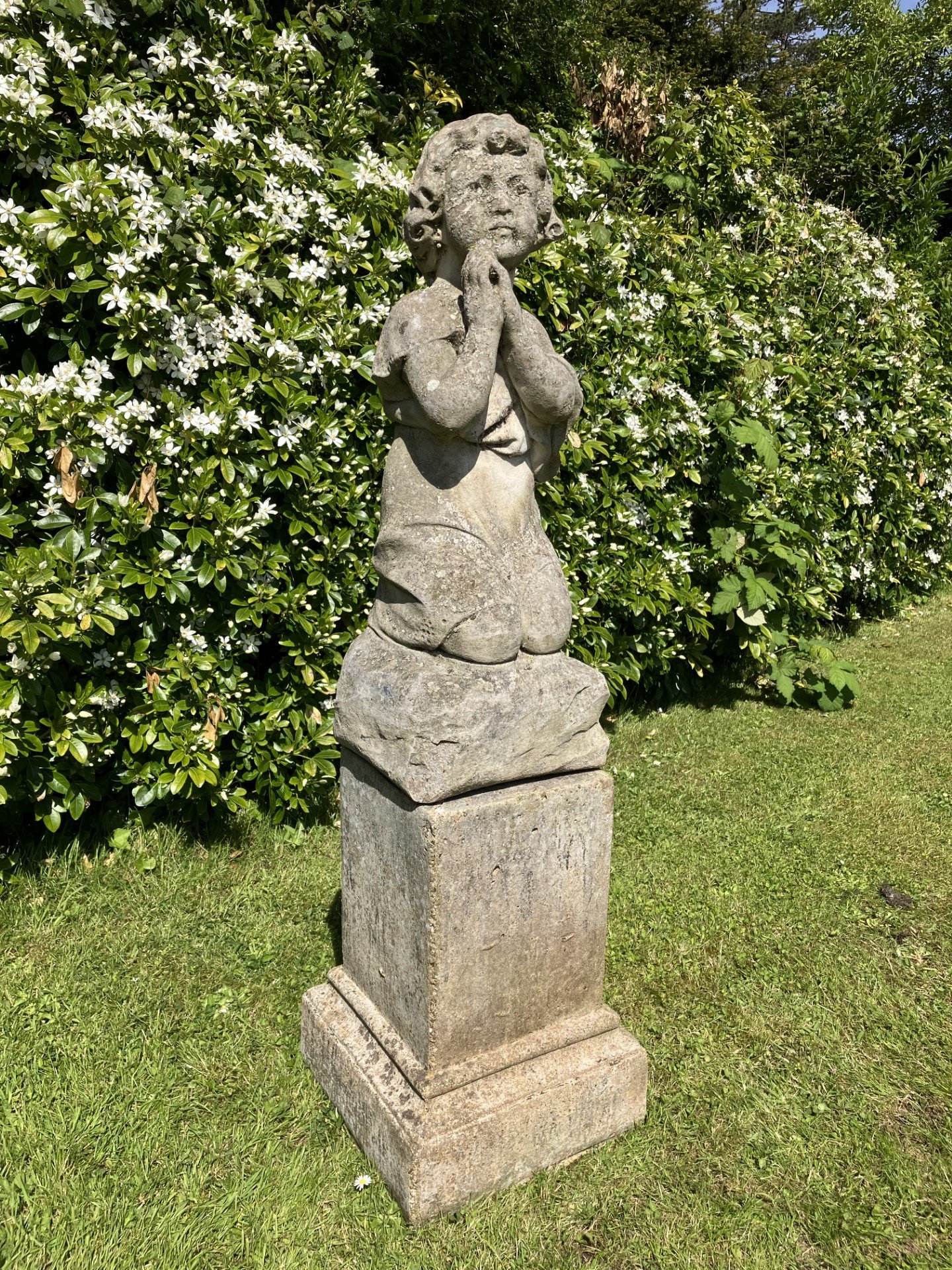 A carved figure on composition stone base