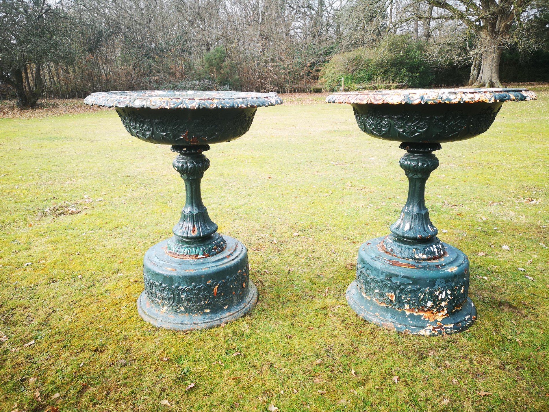 A pair of cast iron urns on pedestals attributed to the Handyside foundry
