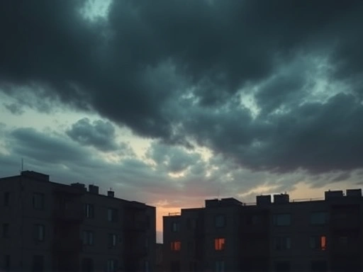 어두운 파스텔 톤으로 표현된 흐린 하늘 아래, 낡고 빈 아파트 단지의 실루엣이 보인다.