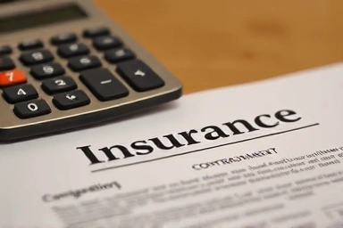 보험 계약서와 계산기가 클로즈업된 이미지