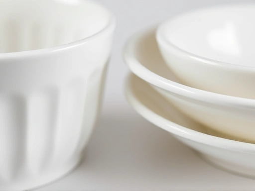 Close-up detailed shot of different types of ceramic and melamine tableware, emphasizing their material differences, surface textures, and edge details for a clear comparison, with keywords ceramic, melamine, tableware, material, texture, detail.
