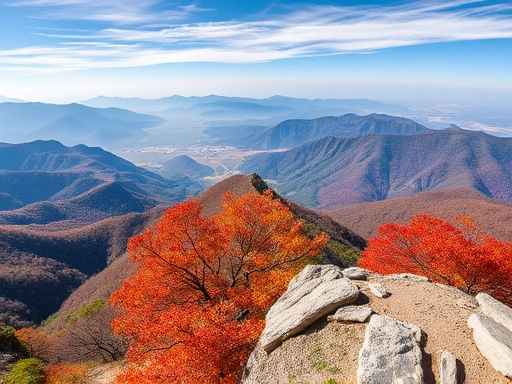 A breathtaking close-up view from Gyeryongsan's summit, showcasing vibrant autumn foliage and distant mountain ranges under a clear sky.