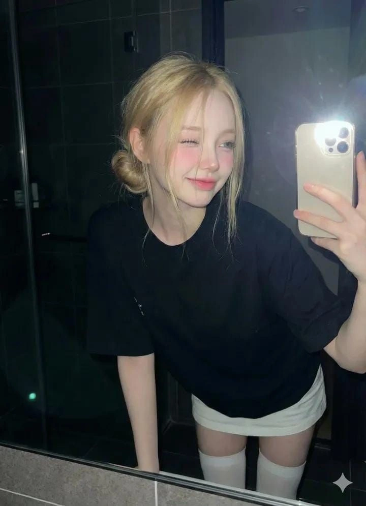 Selfie in a dark bathroom with flash and mirror reflection