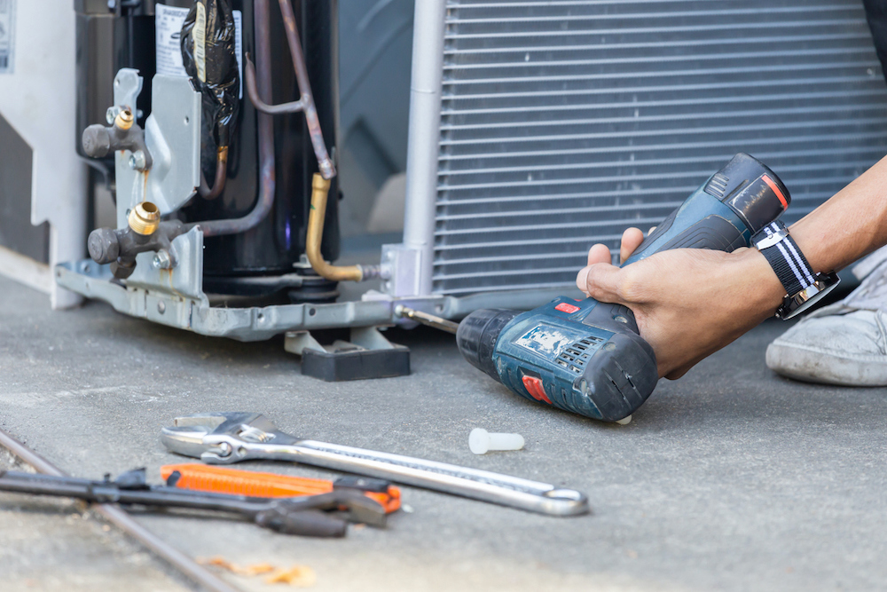 man repairing an air conditioning unit