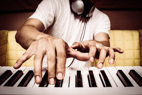 musician hands playing white piano on yellow seat + art filter for music background