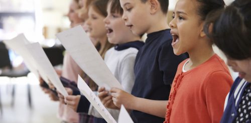 Group Of School Children Singing In Choir Together