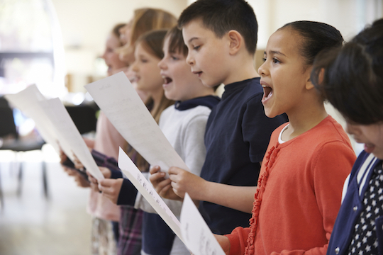 Group Of School Children Singing In Choir Together