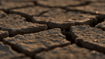 AI-generated extreme zoom-out from a cracked earth texture to a full aerial desert landscape