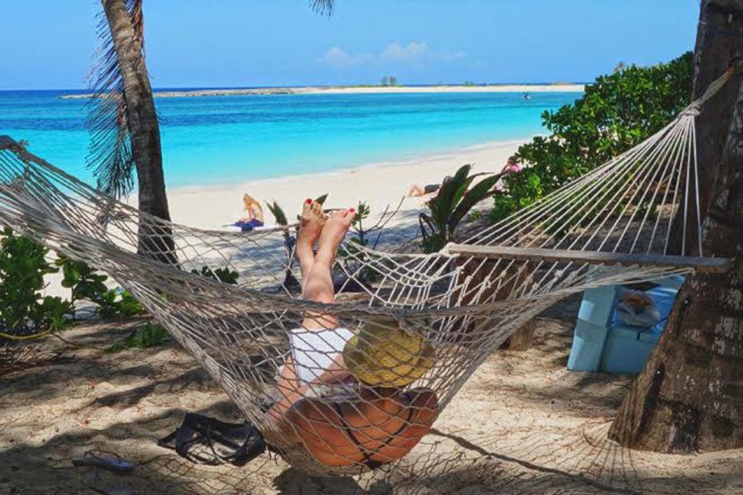 woman relaxing in hammock on beach woman relaxing in hammock on beach