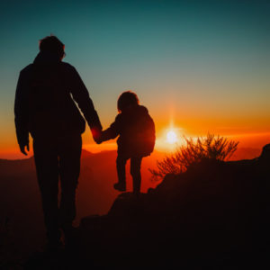 Father and daughter walking together at sunset