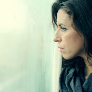 Serious woman looking out window