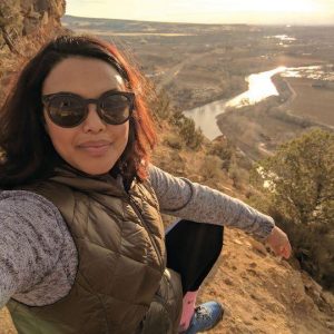 Reverend Aline Silva in sunglasses on a mountainside