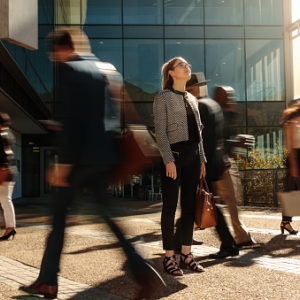 Businesswoman standing still on a busy street