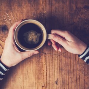 Woman with coffee on wood table