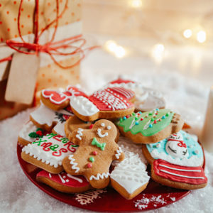 Gingerbread cookies on a red plate next to a glass of milk