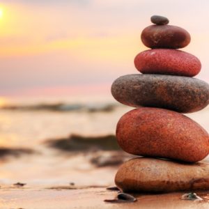 balancing rocks on beach at sunset