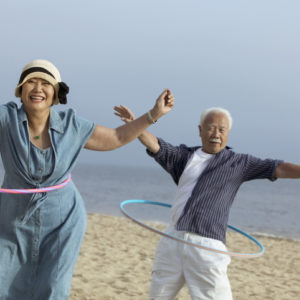 couple hula hooping on a beach