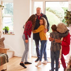 Children welcoming grandparents at the doorway during the holidays