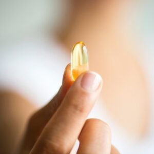 Woman holding fish oil supplement