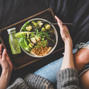 view of a healthy plate on someone's lap seating on couch