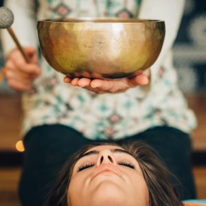 A woman tries healing frequencies using sound bowls