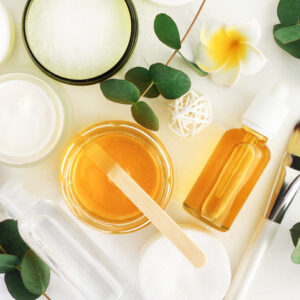 Natural cosmetics ingredients for skin care, body and hair care. Golden honey in jar and green herbal eucalyptus leaves.