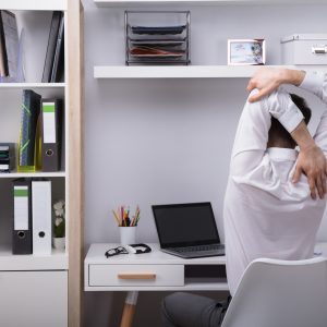 Man at work stretches to ease neck, shoulder, and upper back pain